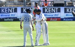 India's Virat Kohli (R) hugs South Africa's Dean Elgar (C) after the latter was out for 12 in his final Test innings