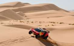 Heading for the rocks: Sebastien Loeb races through the dunes on stage 3 before suffering a series of punctures