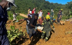 Rescue teams carry a corpse from the area of a landslide in Choco Department, Colombia