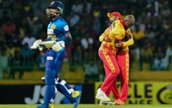 Zimbabwe's Luke Jongwe celebrates with Sikandar Raza (R) after taking the wicket of Sri Lanka's Kusal Mendis (L) during the second T20 between Sri Lanka and Zimbabwe