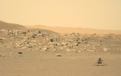 NASA's tiny Ingenuity helicopter is seen sitting on the surface of Mars in a photograph taken by the rover Perseverance 