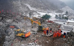 Rescue workers search for missing victims at a landslide site, a day after it hit Liangshui village in southwestern China's Yunnan province