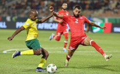 South Africa forward Percy Tau (L) crosses under pressure from Tunisia defender Ali Abdi
