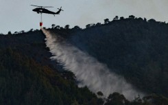 A helicopter from the Colombian Police drops water to put out a forest fire in Bogota 