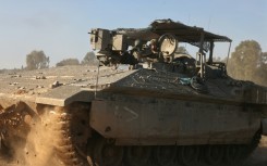 An Israeli military armoured vehicle rolls near the border with the Gaza Strip 