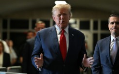 Former US President Donald Trump speaks to the press as he arrives at Manhattan Criminal Court for a hearing in his case of allegedly paying hush money to cover up an affair