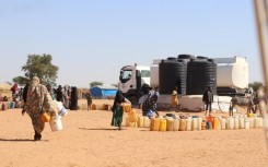 Refugees fleeing the conflict in Sudan queue to collect drinking water from the Doctors Without Borders (MSF) distribution point at Ourang refugee camp in Adre, Chad on December 7, 2023