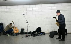 In an airy spot between two escalators a small group of musicians are unpacking their instruments, checking their music and calming any last minute nerves