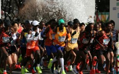 Men's elite runners including eventual winner Benson Kipruto (4th from right) and Eliud Kipchoge (white cap) set off at the start of the Tokyo marathon  