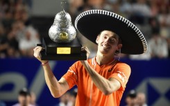 Australia's Alex de Minaur celebrates with his trophy after winning the ATP Mexico Open final over Norway's Casper Ruud