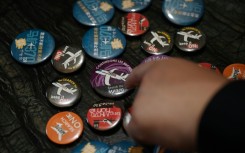 Jiang Hui, whose mother was on board flight MH370, shows buttons commemorating the missing flight