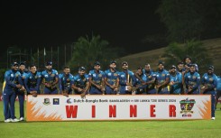 Sri Lanka's cricketers pose with the Twenty20 trophy after winning the three-match series against Bangladesh 2-1 -- pointing to their watches in an apparent reference to  the "timed out" controversy of last year's World Cup 