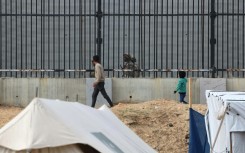 Displaced Gazans in the Rafah camps can see Egyptian soldiers on patrol just across the border fence