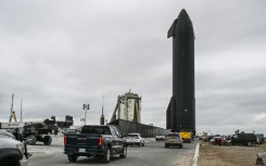 People gather as SpaceX Starship spacecraft prototype is transported from the launch site ahead of the SpaceX Starship third flight test from Starbase in Boca Chica, Texas 