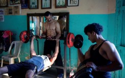 Walter Perez (C) helps a young man train in the gym he and his brother Arturo run in a town south of Managua