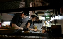 Agustina Bovi (L) cooks at the small vegan restaurant 'Yedra,' in Buenos Aires, but even with another job on the side she's living through her 'worst period from an economic point of view'
