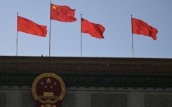 Chinese flags flutter atop the Great Hall of the People in Beijing on March 3, 2024, ahead of the country's annual legislative meetings known as the "Two Sessions".
