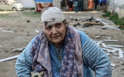 Palestinian Hoda al-Arouqi, 75, who was injured during overnight Israeli bombardment, inspects the damage to her home in Rafah in the southern Gaza Strip on March 25, 2024