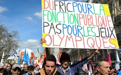 A protester holds a banner reading 'Cash for civil services, not for the Olympic Games' during a demonstration last week
