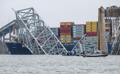 The collapsed Francis Scott Key Bridge lies on top of the container ship Dali in Baltimore, Maryland, on March 27, 2024