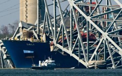 The collapsed Francis Scott Key Bridge lies on top of the container ship Dali in Baltimore, Maryland, on March 29, 2024, as clean-up work begins