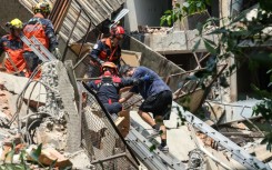 A Central News Agency photo shows emergency workers assisting a survivor after he was rescued from a damaged building in New Taipei City