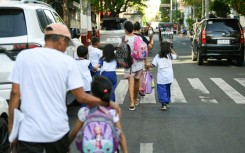 Parents accompany their children from school in Manila after dangerously high temperatures forced the Philippines to suspend in-person classes in 5,288 schools