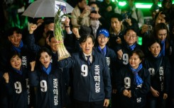 Cho Kuk, leader of the Rebuilding Korea Party, holds up green onions at a campaign event in Seoul on March 28, 2024