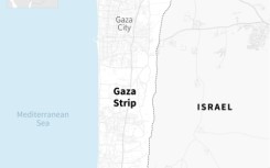 Two men ride a donkey-drawn cart amid the rubble of destroyed buildings in Khan Yunis on April 7, 2024 