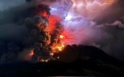 The crater of Mount Ruang flamed with lava against a backdrop of lightning bolts overnight after erupting five times