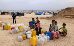 Displaced Palestinian children wait for water at their tent camp in Rafah -- the UN children's agency estimates the war has displaced around 850,000 children in Gaza