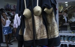 A woman looks at merchandise inspired by US pop star Madonna, including a conical corset top, at a shop in Rio de Janeiro