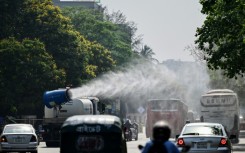 A vehicle of the Dhaka North City Corporation sprays water along a busy road to lower the temperature amidst a heatwave