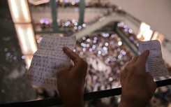 People hold the lyrics to 'Glory to Hong Kong’ at a shopping mall during the city's 2019 democracy protests