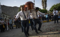 Peru's 'dancer's of death' show off intricate footwork as they bear a coffin to its final resting place 