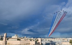 The French Air Force display team  sprays the colours of the French flag above Marseille's Old Port as the Olympic flame arrives