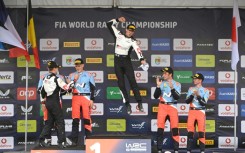 Sebastien Ogier (C) celebrates a record sixth Rally of Portugal victory