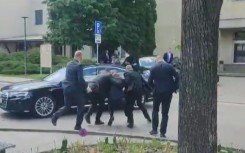 Security men help Slovakia's wounded Prime Minister Robert Fico to his car