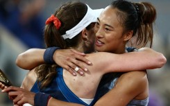 All over:  Zheng Qinwen embraces Alize Cornet after ending the Frenchwoman's career on Tuesday 