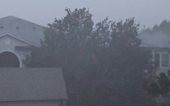 A group of men board up a restaurant in Port Lavaca, Texas, on July 7, 2024, as they prepare for the arrival of tropical storm Beryl