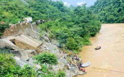Rescuers search for survivors in the river Trishuli in Simaltar after a landslide triggered by heavy rains swept two buses off a highway 