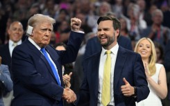 Republican vice presidential candidate J.D. Vance (R) shakes hands with Donald Trump during the second day of the 2024 Republican National Convention