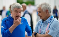 International Olympic Committee President Thomas Bach speaks to IOC member Juan Antonio Samaranch Junior at the Athletes' Village