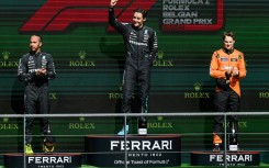 George Russell (C) celebrates his win in the Belgian Grand Prix where he finished ahead of Mercedes teammate Lewis Hamilton (L) and McLaren's Oscar Piastri (R)