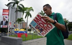 A man reads a newspaper in Caracas on July 29, 2024, a day after the Venezuelan presidential election