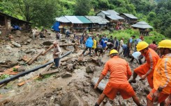 A handout picture from India's National Disaster Response Force shows rescue workers clearing up a landslide site near Shimla