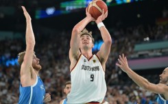 Germany's Franz Wagner takes a shot over Greece's Thomas Walkup and Nick Calathes in Germany's quarter-final win in the Olympic men's basketball tournament