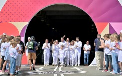 Former French wheelchair fencer Emmanuelle Assmann (C) emerges from the Channel Tunnel with the flame for the 2024 Paralympic Games 