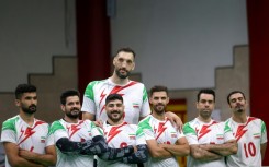 Morteza Mehrzad towers over his teammates in Iran's sitting volleyball team
