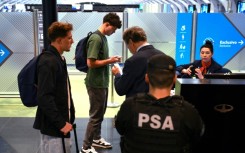 French rugby players Oscar Jegou (L) and Hugo Auradou (2nd L) and their lawyer Rafael Cuneo Libarona (3rd R), wait before taking a flight to France at the Ezeiza International Airport, Buenos Aires